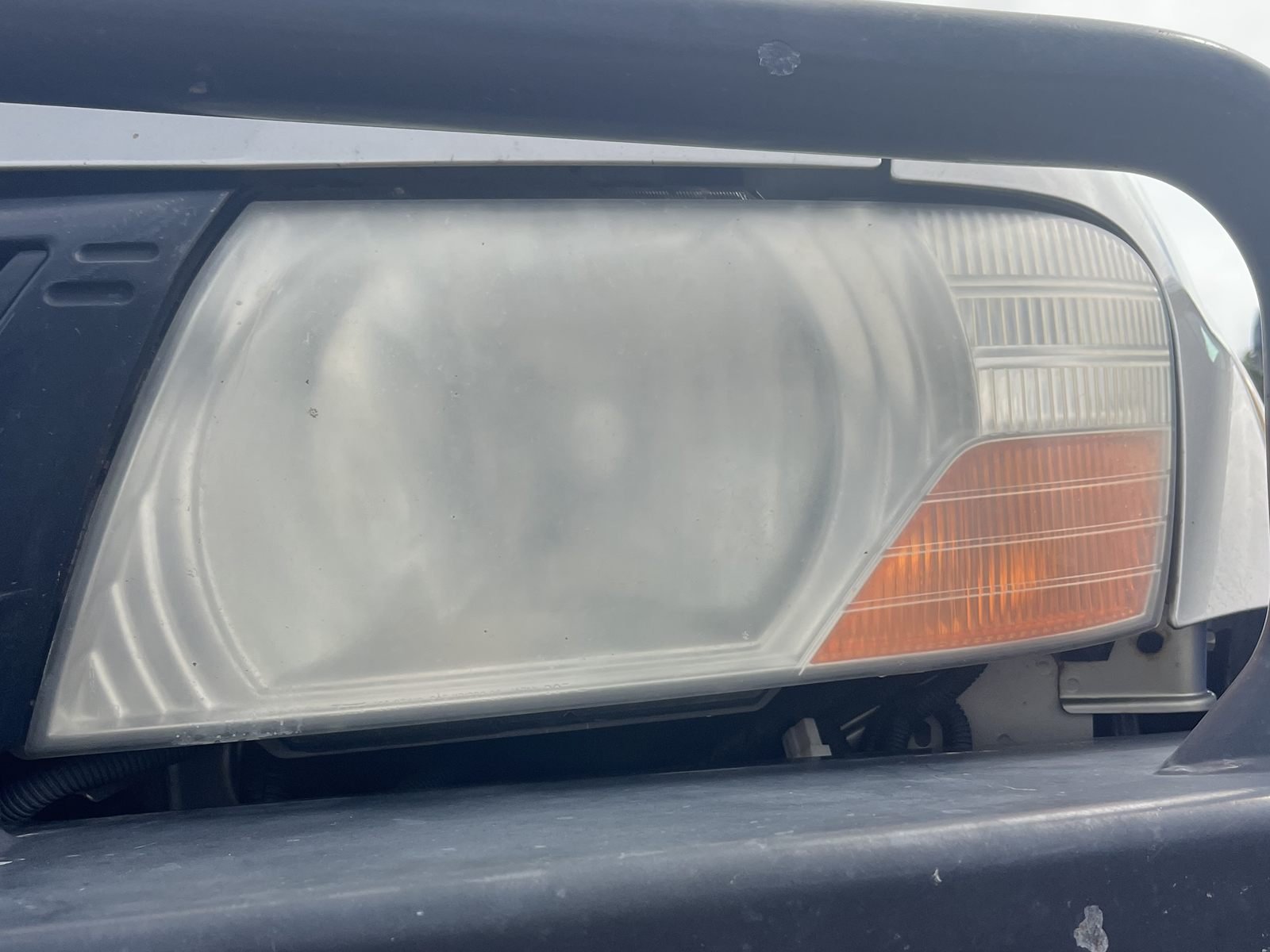 Mitsubishi Pajero headlight before restoration — yellowed and cloudy