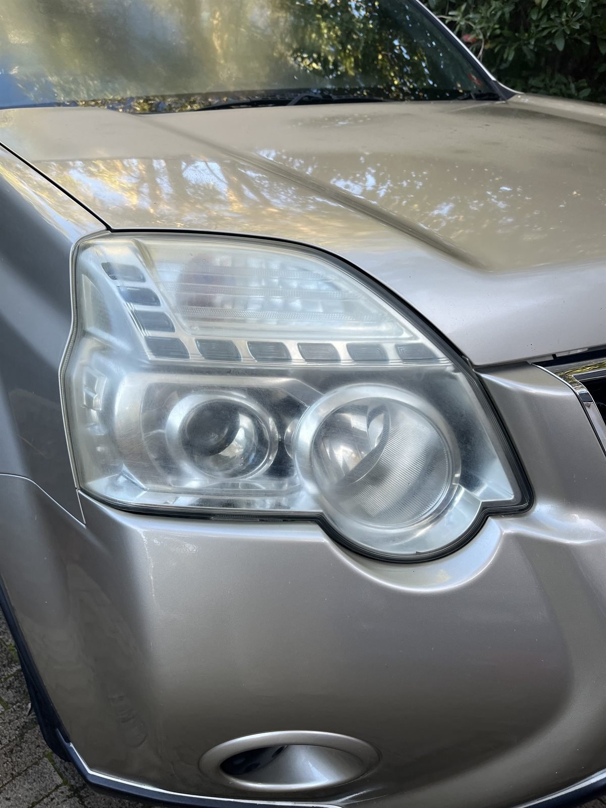 Nissan X-Trail headlight before restoration — yellowed and cloudy